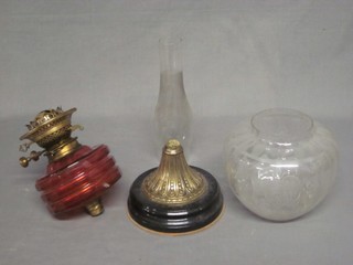 A Victorian red glass oil lamp reservoir with etched glass shade and clear glass chimney, raised on a gilt metal base, faulty,