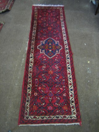 A contemporary red ground Eastern runner with all-over geometric design 76" x 24"