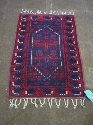 A red and blue ground Eastern rug with lozenge shaped medallion to the centre 40" x 28"