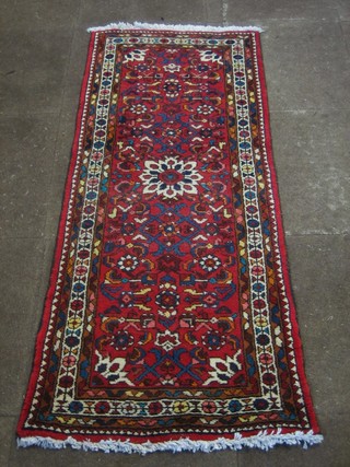 A contemporary red ground Eastern rug with all-over geometric design 59" x 25"