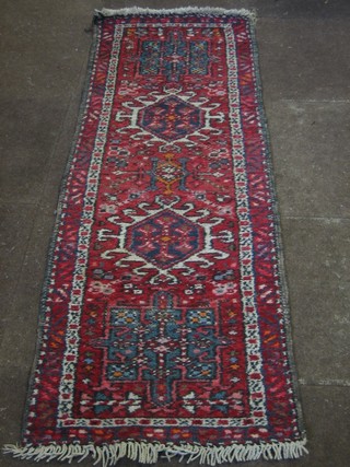 An Eastern red ground runner with geometric decoration to the centre 65" x 43"