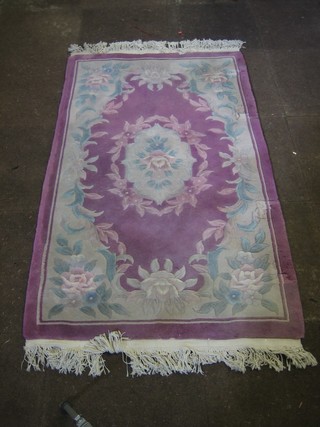 A Chinese purple ground floral patterned rug with sculpted decoration 61" x 36"