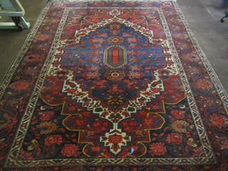 A blue and red ground Persian carpet with central medallion within multi row borders and floral decoration, some wear, 125" x 84"