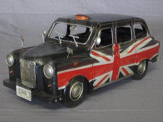 A pressed metal model of a London taxi with Union Jack decoration