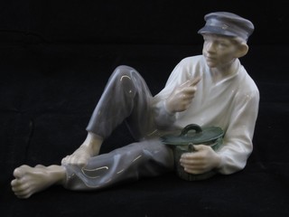 A Royal Copenhagen figure of a reclining man with biscuit, the base marked Royal Copenhagen 865 6"