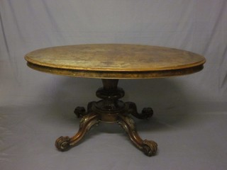 A Victorian oval figured walnut snap top Loo table raised on a turned column and tripod base, the blistering and requiring attention, 57"
