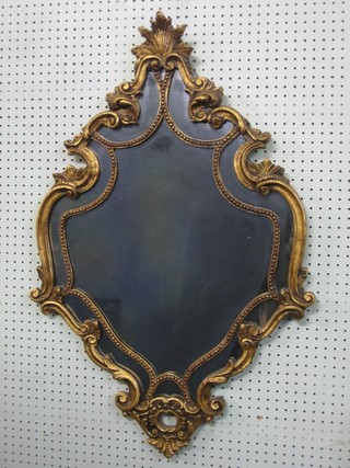 A shaped plate mirror contained in a decorative gilt frame 36"