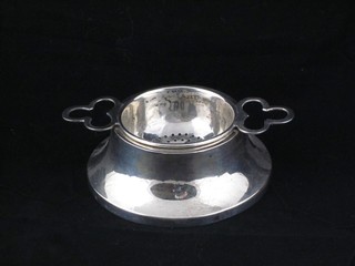 A modern silver tea strainer and stand