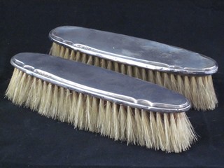 A pair of oval silver backed clothes brushes