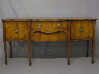 A Georgian style mahogany sideboard of serpentine outline the crossbanded top fitted 2 long drawers flanked by a pair of cupboards, raised on square tapering supports ending in spade feet 72"