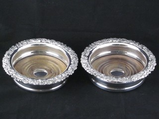 A pair of circular silver plated wine bottle coasters