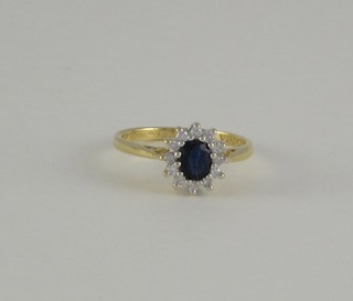 An 18ct yellow gold cluster dress ring set a sapphire surrounded by diamonds