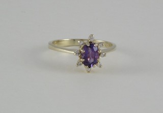 A 9ct gold dress ring set an amethyst supported by diamonds