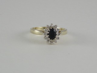 A 9ct gold dress ring set an oval cut sapphire surrounded by diamonds