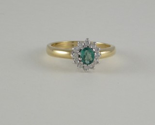 A lady's 18ct yellow gold dress ring set an oval cut emerald supported by diamonds