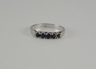 A white metal dress ring set 5 blue stones, 1 missing