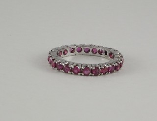 A white metal full eternity ring set red stones