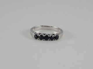 A white metal dress ring set 5 blue stones
