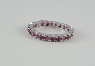 A lady's white metal full eternity ring set red stones
