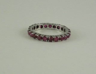 A white metal full eternity ring set red stones