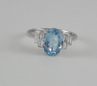 A lady's 18ct white gold dress ring set an oval cut aquamarine and with 6 diamonds to the shoulders