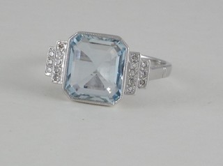 An 18ct lady's gold dress ring set an aquamarine, the shoulders set diamonds