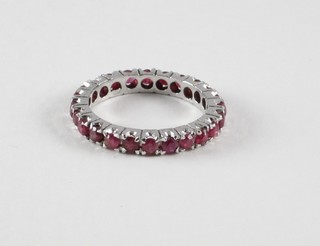 A lady's white metal full eternity dress ring set red stones