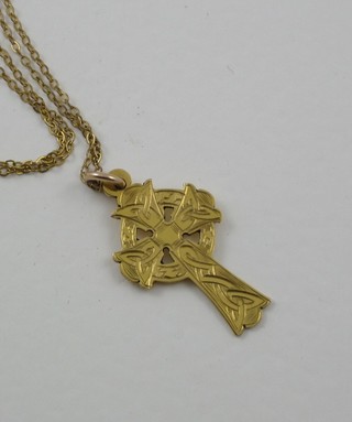 A gold Celtic cross hung on a fine gold chain