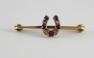 A 15ct gold bar brooch in the form of a horse shoe set rubies and diamonds