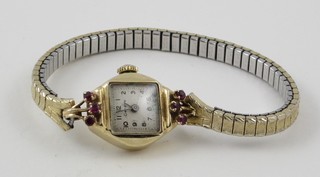 A lady's Geneva wristwatch contained in a gold and jewelled case