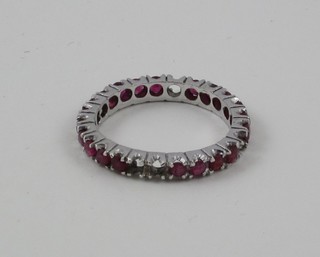 A white metal full eternity ring set red stones