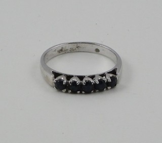 A white metal half eternity ring set blue stones