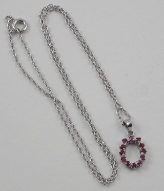 A fine silver chain hung a pendant set red stones