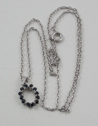 A fine silver chain hung a pendant set blue stones