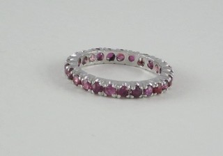 A white metal full eternity ring set red stones