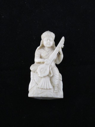 A carved ivory figure of a seated lady musician