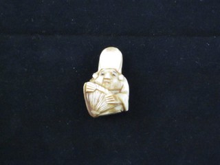 A miniature carved ivory Netsuke in the form of a man 1",