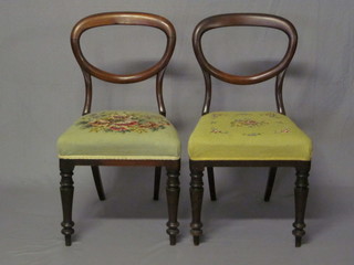 A pair of Victorian mahogany balloon back dining chairs with upholstered seats, raised on turned supports