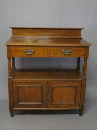 An Edwardian Art Nouveau walnut 2 tier buffet, the upper  section fitted 2 long drawers above a recess, the base fitted a  cupboard enclosed by panelled doors 41"