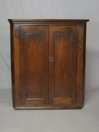 A Georgian oak corner cabinet with moulded cornice and shelved interior enclosed by panelled doors 37"