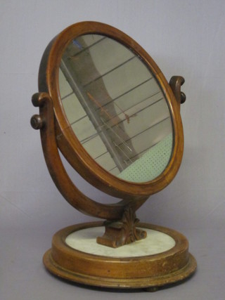A Victorian circular plate dressing table mirror contained in a rosewood frame, raised on a circular marble and mahogany base  