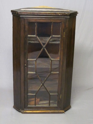 A 19th Century shaped mahogany hanging corner cabinet, the  interior fitted shelves enclosed by astragal glazed panelled doors  25" 