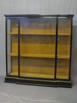 A Victorian ebonised breakfront display cabinet fitted shelves enclosed by a glazed panelled door, raised on a platform base 60"