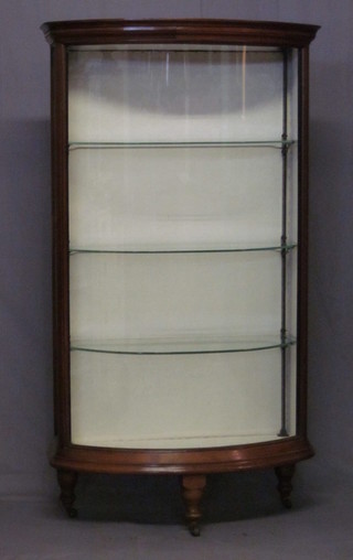 An Edwardian mahogany bow front display cabinet, fitted shelves and raised on turned supports 24"
