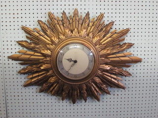 A 1930's Smiths electric wall clock contained in a carved wooden sunburst case, 27"