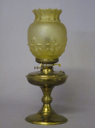 A brass oil lamp with glass shade