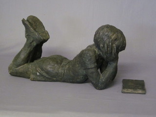 A resin figure of a reclining boy reading a book, 22"