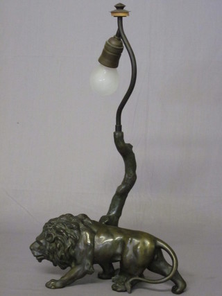 A bronze table lamp in the form of a walking lion by a tree 13"