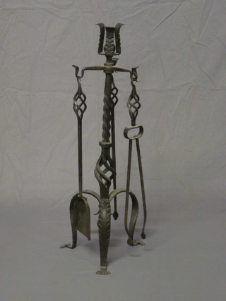 A large wrought iron 4 piece fireside companion set, comprising  pair of tongs, poker and shovel