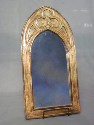 An arched plate wall mirror contained in a carved Gothic style hardwood frame 24"